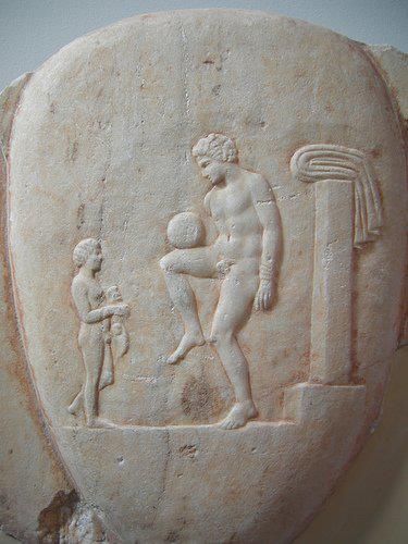 Greek marble relief of a man with a ball on his knee (400 BCE).